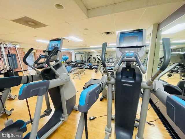workout area featuring visible vents, wood finished floors, and a drop ceiling