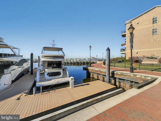 view of dock with fence and a water view