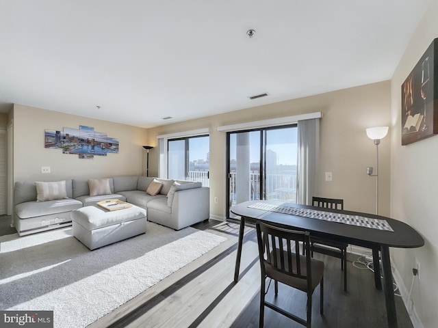 living room featuring baseboards, wood finished floors, and visible vents
