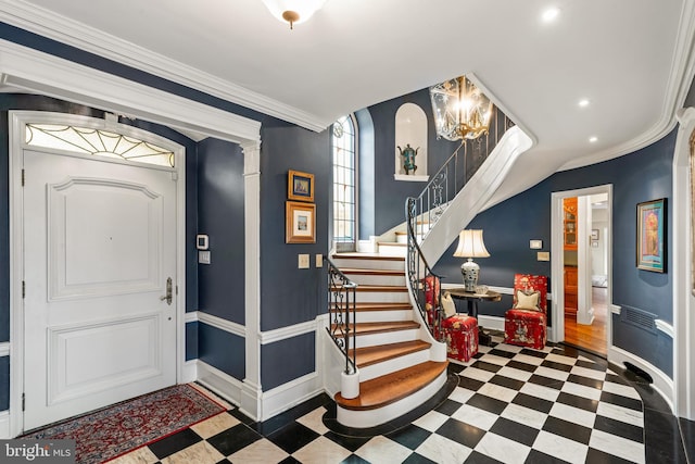 entrance foyer featuring ornamental molding and a notable chandelier