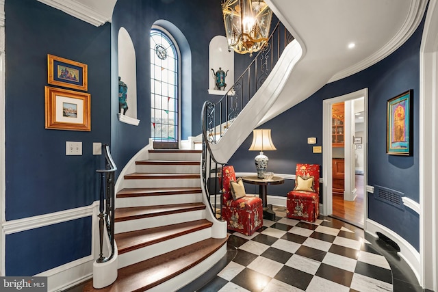 stairs featuring a notable chandelier and crown molding