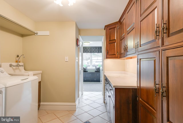 washroom with light tile patterned flooring, washing machine and clothes dryer, and cabinets