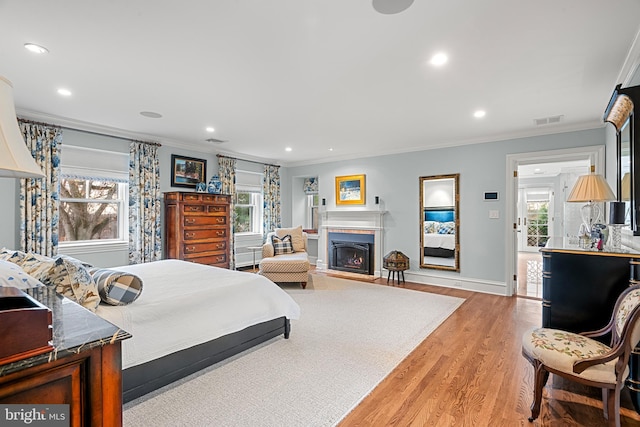 bedroom featuring ornamental molding and light hardwood / wood-style flooring