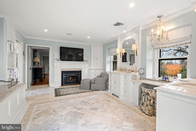 bathroom with sink, a chandelier, and ornamental molding