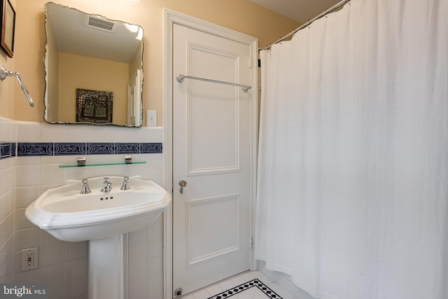 bathroom with tile walls and tile patterned floors