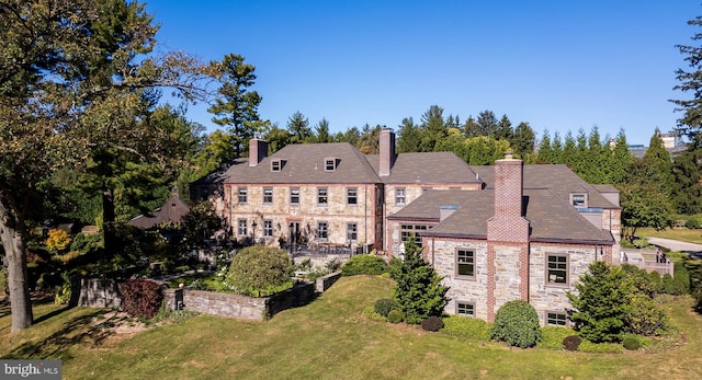 rear view of property with a lawn