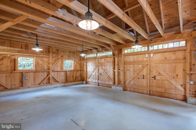 misc room with concrete flooring and wooden walls