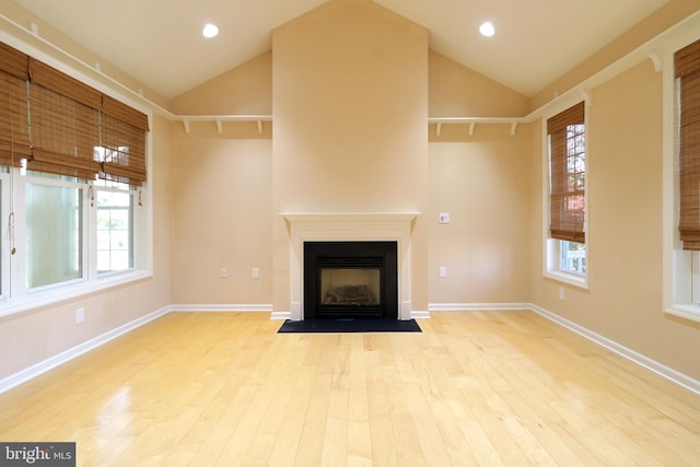 unfurnished living room featuring vaulted ceiling and light hardwood / wood-style flooring