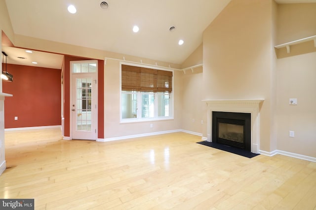 unfurnished living room featuring vaulted ceiling and light wood-type flooring