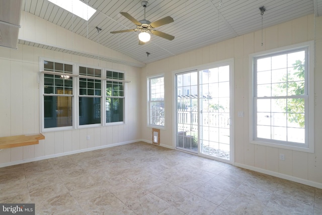 spare room with vaulted ceiling with skylight and ceiling fan