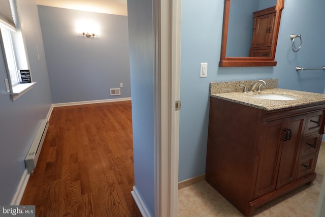 bathroom with vanity, hardwood / wood-style flooring, and baseboard heating