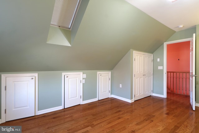 additional living space featuring wood-type flooring and vaulted ceiling