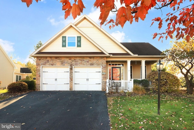 view of front facade with a front yard, a garage, and covered porch