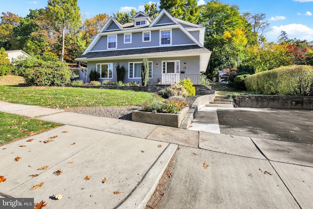 view of front facade featuring covered porch and a front yard