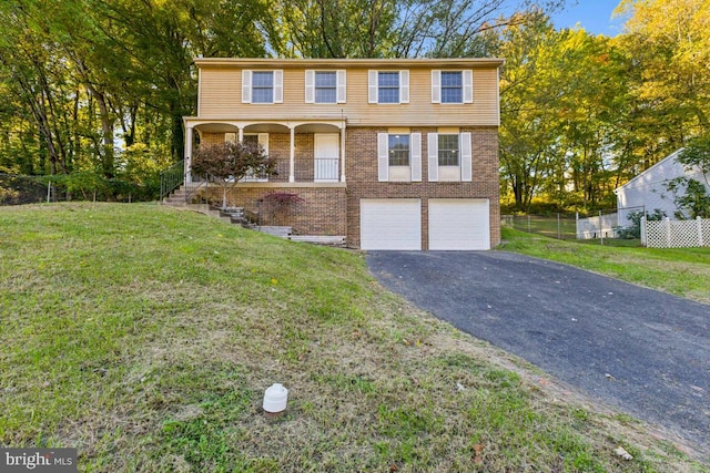 view of front of home with a porch, a front yard, and a garage