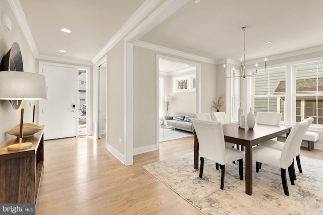 dining room featuring light hardwood / wood-style flooring, crown molding, and a notable chandelier