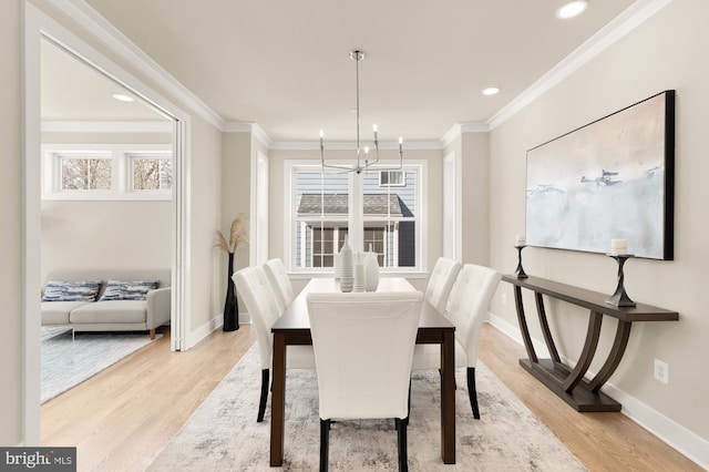 dining room featuring a notable chandelier, ornamental molding, and light wood-type flooring