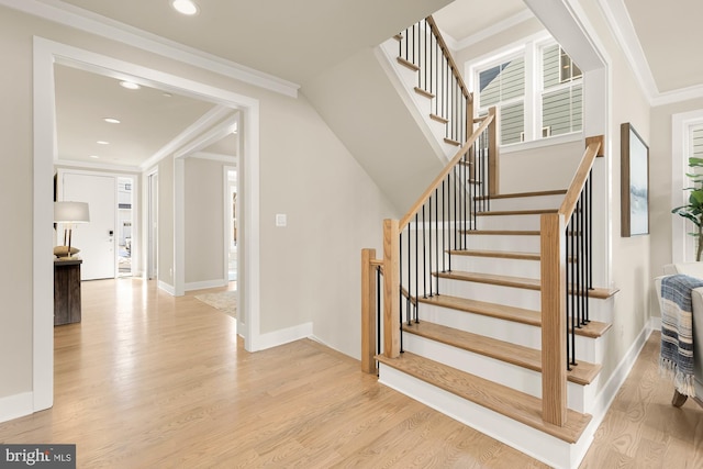 stairs with hardwood / wood-style flooring and crown molding