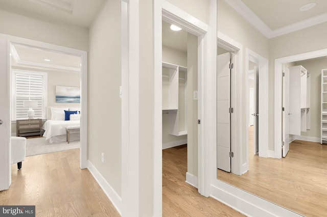 hall with light wood-type flooring and crown molding