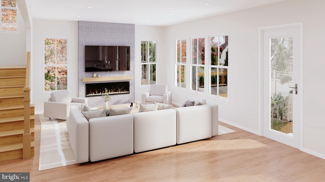 living room with light wood-type flooring and a large fireplace