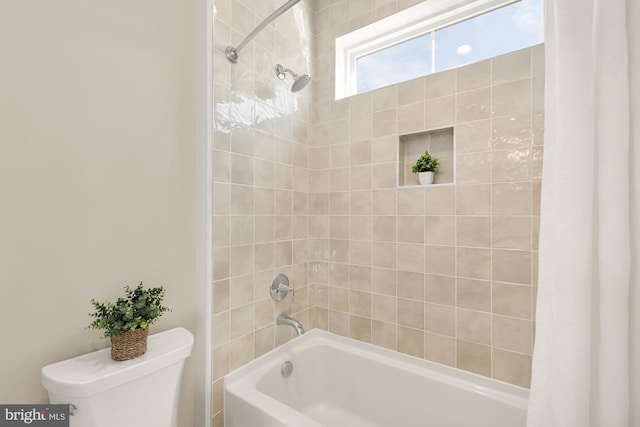 bathroom featuring shower / bath combo and toilet