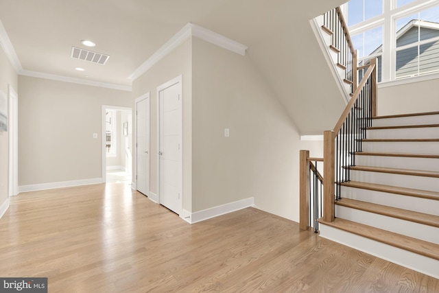 interior space featuring crown molding and light hardwood / wood-style flooring