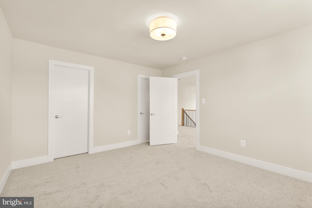 unfurnished bedroom featuring light carpet