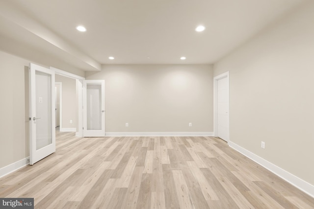 spare room featuring light hardwood / wood-style flooring and french doors