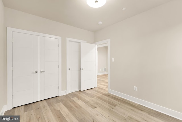 unfurnished bedroom with light hardwood / wood-style floors and a closet