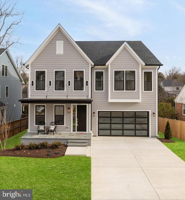 view of front of house featuring a front yard, a garage, and a porch