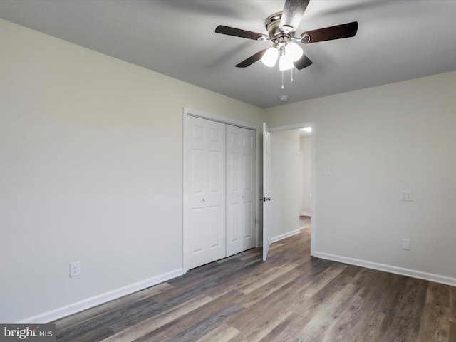 unfurnished bedroom featuring dark hardwood / wood-style flooring, a closet, and ceiling fan