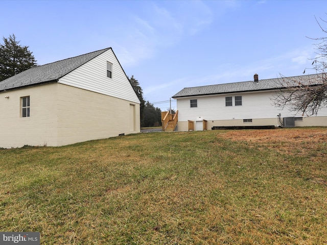 back of house with a yard and central air condition unit