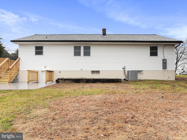 rear view of house with a yard and central AC unit