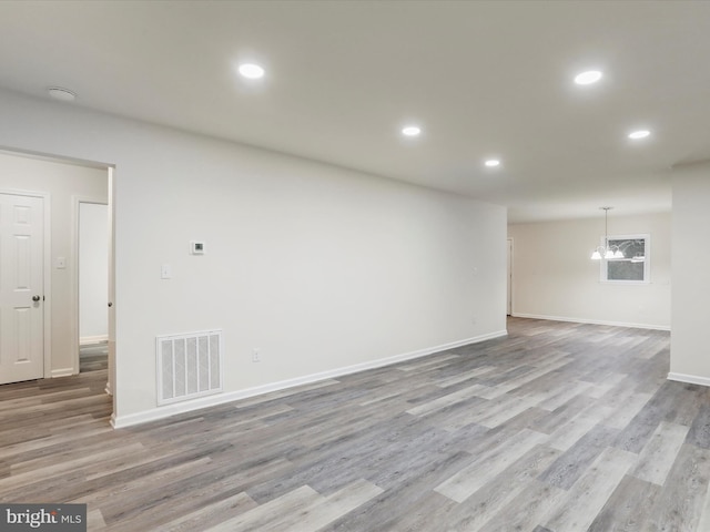 unfurnished room featuring light hardwood / wood-style flooring and a notable chandelier