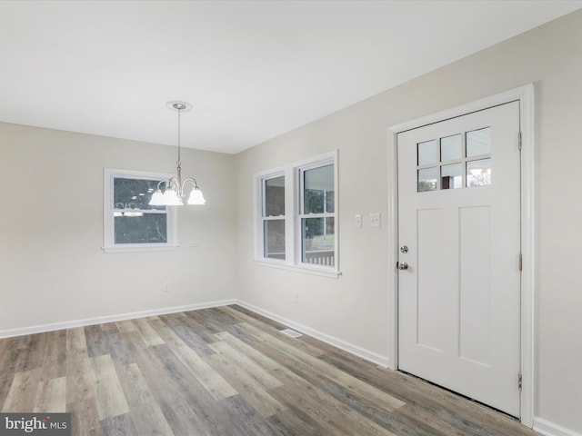 entryway featuring light hardwood / wood-style flooring and an inviting chandelier