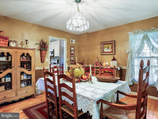 dining room featuring light hardwood / wood-style floors and a chandelier