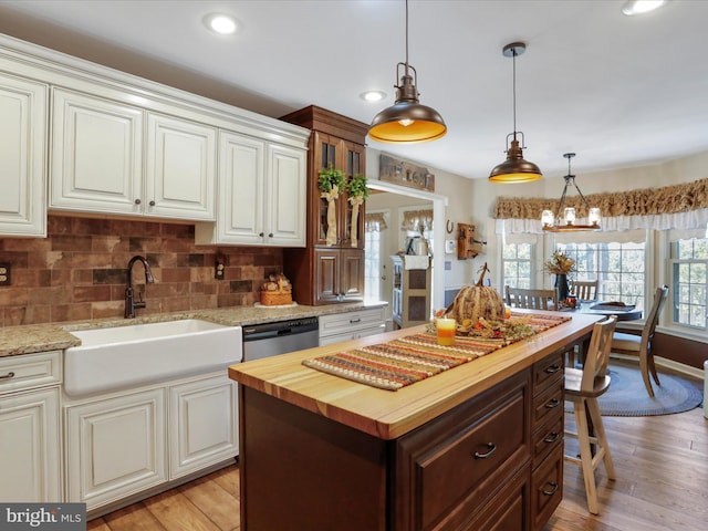 kitchen featuring wooden counters, light hardwood / wood-style floors, hanging light fixtures, and a kitchen island