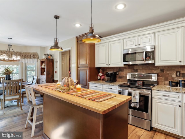 kitchen with light wood-type flooring, wooden counters, a center island, and stainless steel appliances