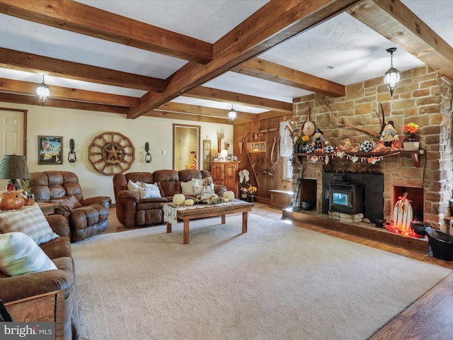 living room featuring a fireplace, a textured ceiling, wooden walls, hardwood / wood-style flooring, and beamed ceiling