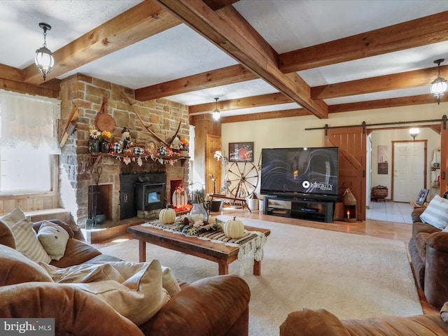 tiled living room with a barn door and beam ceiling