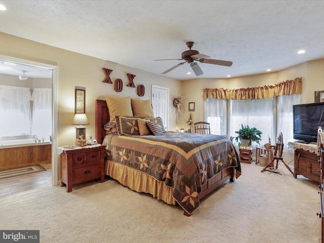 bedroom featuring a textured ceiling, light carpet, and ceiling fan