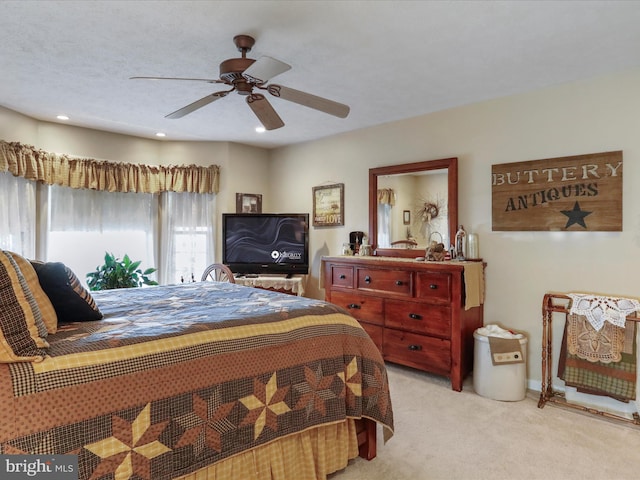 bedroom with a textured ceiling, light carpet, and ceiling fan