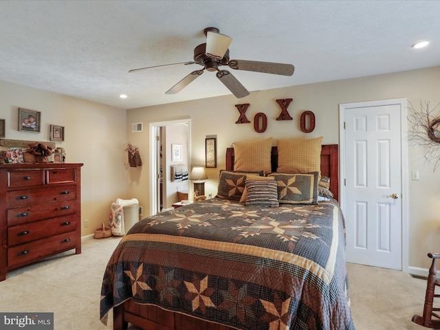 bedroom with ceiling fan, a textured ceiling, and light colored carpet