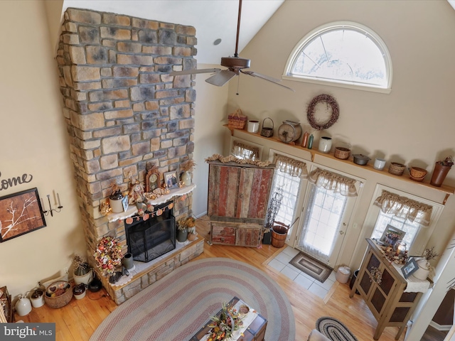 living room with high vaulted ceiling, light hardwood / wood-style floors, ceiling fan, and a fireplace