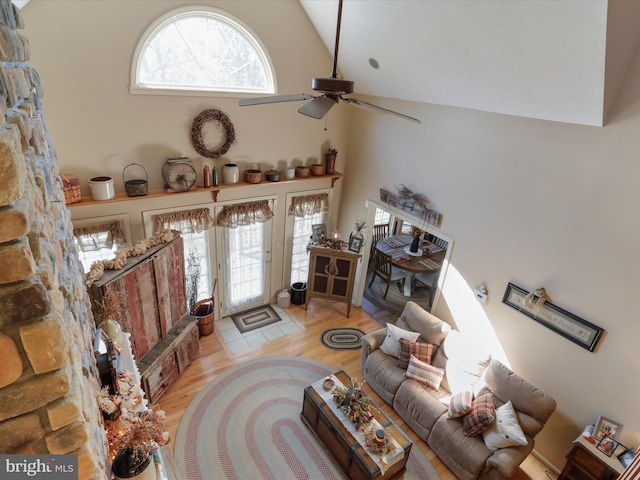 living room featuring ceiling fan, light wood-type flooring, and high vaulted ceiling