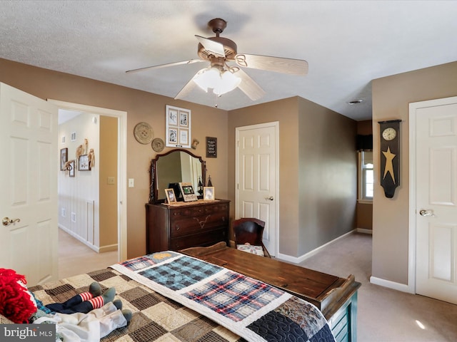 bedroom featuring ceiling fan, a textured ceiling, and light colored carpet