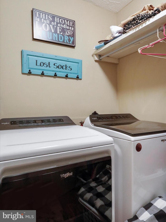 laundry room featuring separate washer and dryer and a textured ceiling