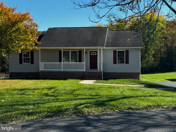 ranch-style house with a front yard and covered porch