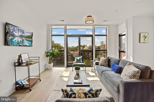 living room with light wood-type flooring and floor to ceiling windows