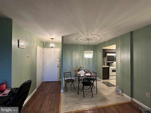 dining space with light hardwood / wood-style flooring and a notable chandelier